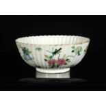 A polychrome porcelain ribbed bowl with scalloped rim and a decor of flowers and insects. Marked