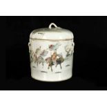 A fencai porcelain cylinder pot with cover with a decor of figures in a garden. Marked with seal