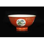 A red porcelain medallion bowl with a polychrome decor of several landscapes and gold colored floral