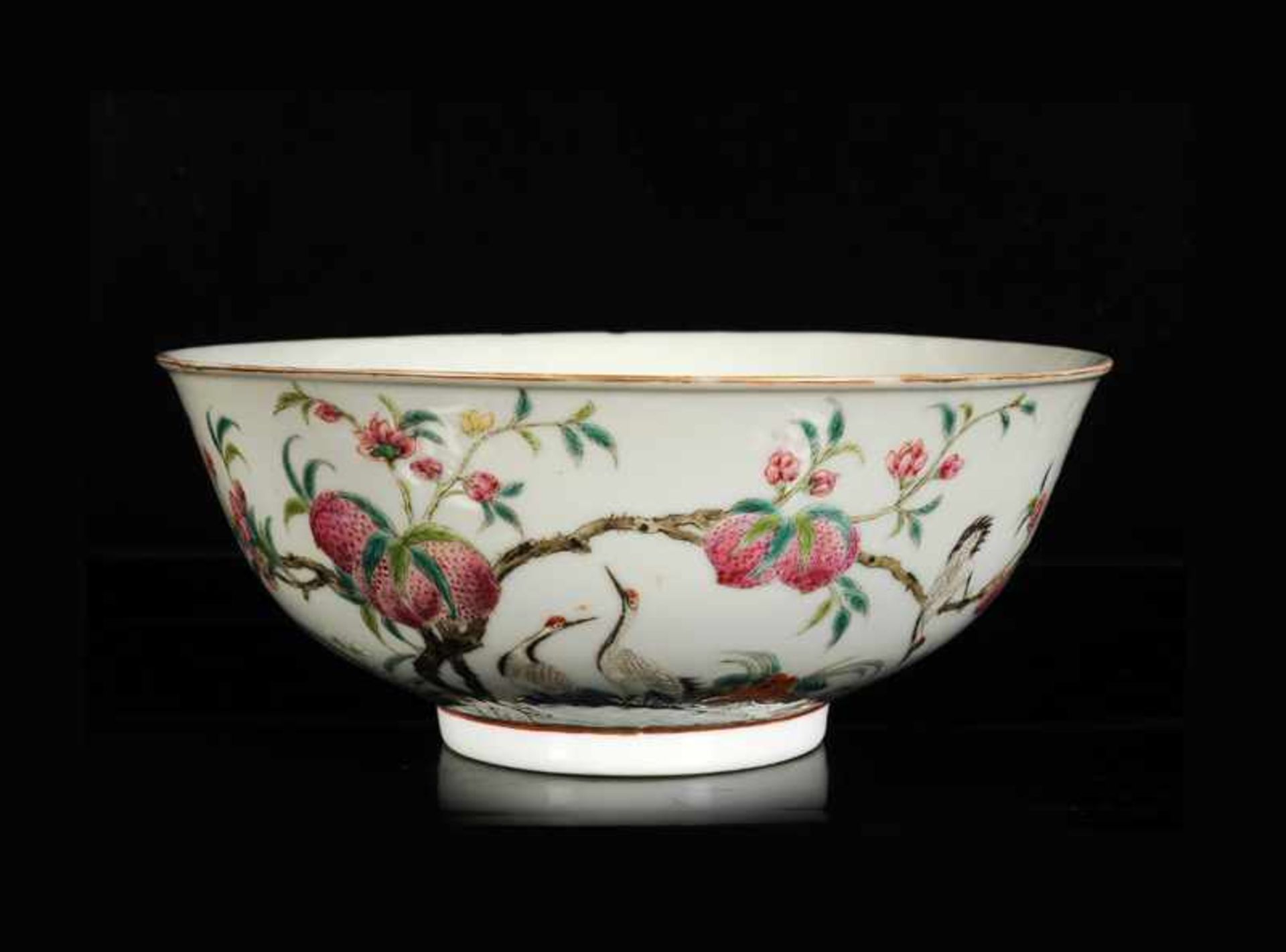 A polychrome porcelain bowl with a decor of peaches and cranes. Marked with six-character mark