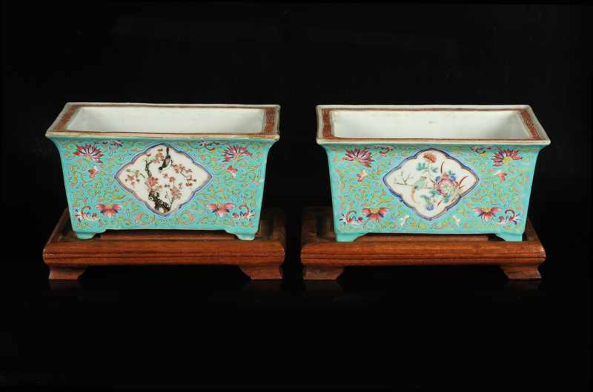 A pair of green glazed porcelain jardinières with a polychrome decor of birds and flower branches.