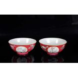 A pair of red porcelain medallion bowls with a decor of flowers. Marked with seal mark Qianlong.