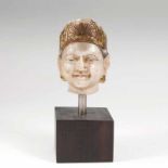 Alabasterkopf eines Buddha Indien, 12./13. Jh. Alabaster mit Resten von Gold- und Farbbemalung,