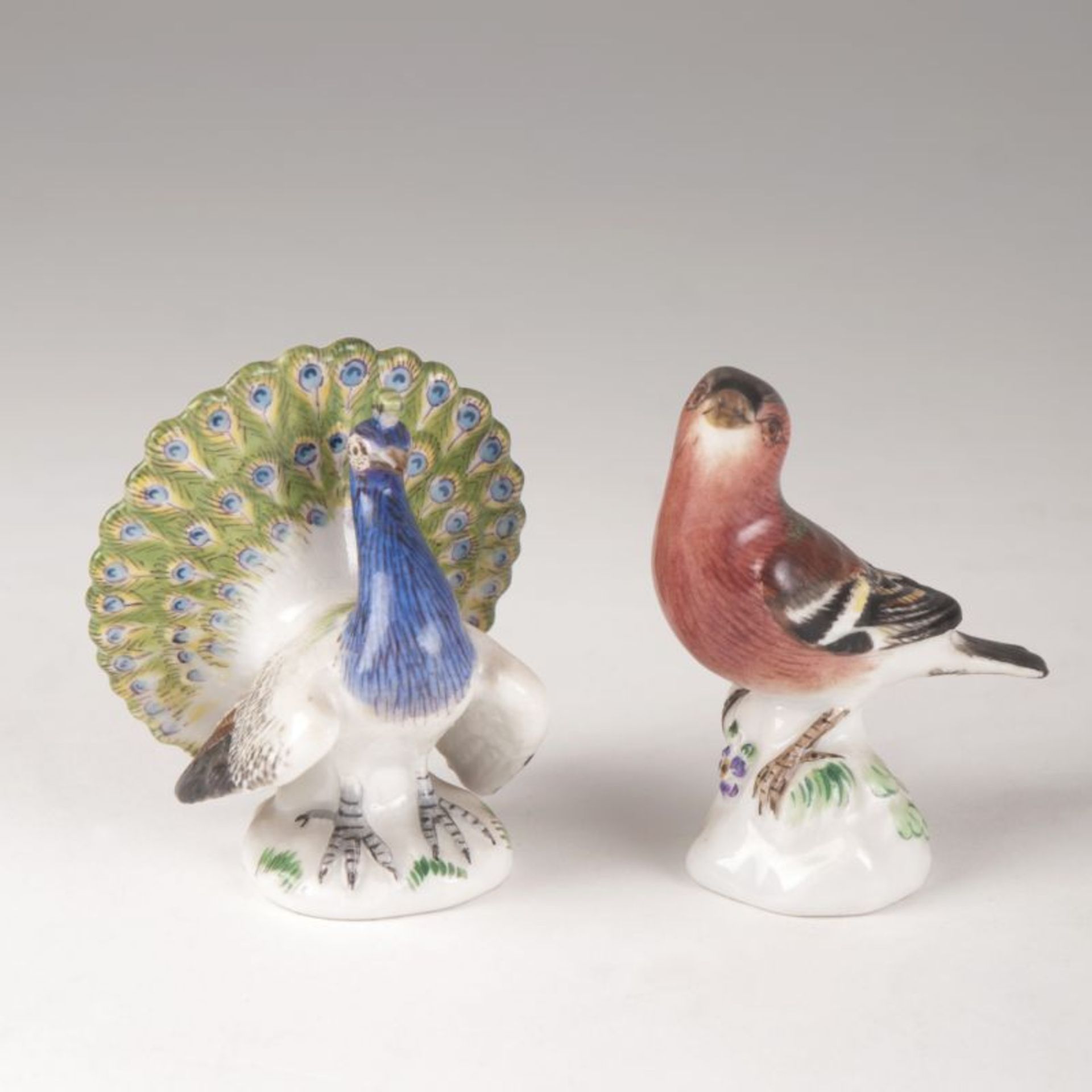 Paar Miniatur-Vogelfiguren Meissen, 20. Jh. Porzellan, farbig staffiert. Pfau und Buchfink (Chip).