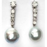 A PAIR OF DIAMOND AND SOUTH SEA PEARL PENDANT EARRINGS each designed as a graduated line of round