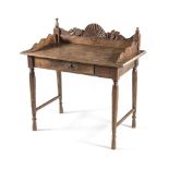 AN INDONESIAN WRITING TABLE the rectangular top surmounted by a carved an shaped three-quarter