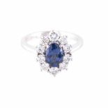 A SAPPHIRE AND DIAMOND RING centred with an oval mixed-cut sapphire, weighing approximately 1.39cts,