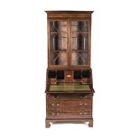 A GEORGE III STYLE MAHOGANY BUREAU BOOKCASE in two parts, the outswept cornice above an inlaid