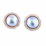 A PAIR OF MABÉ PEARL AND DIAMOND EAR STUDS each centred with a pinkish blue mabé pearl, within a