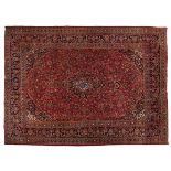 A KESHAN CARPET, PERSIA, MODERN the madder-red field with an indigo-blue floral medallion, similar