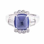 A TANZANITE AND DIAMOND RING centred with a cushion-cut tanzanite weighing 4.39cts, flanked on