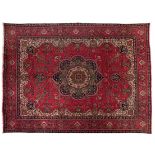 A TABRIZ CARPET, NORTH WEST PERSIA, MODERN the red field with a blue and green floral medallion,