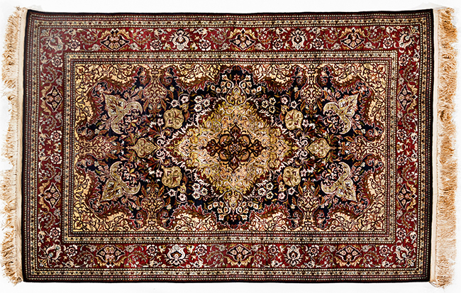 AN EGYPTIAN SILK RUG, MODERN the deep indigo-blue field with an ivory floral medallion, similar