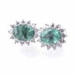 A PAIR OF EMERALD AND DIAMOND EAR STUDS each centred with an oval mixed-cut emerald, weighing