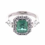 AN EMERALD AND DIAMOND RING centred with a square emerald-cut emerald weighing approximately 1.