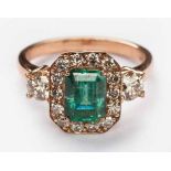 AN EMERALD AND DIAMOND RING centred with an emerald-cut emerald weighing approximately 1.13cts,