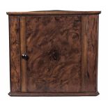 A FLAME MAHOGANY APPRENTICE CORNER CUPBOARD, 19TH CENTURY the triangular top above a door