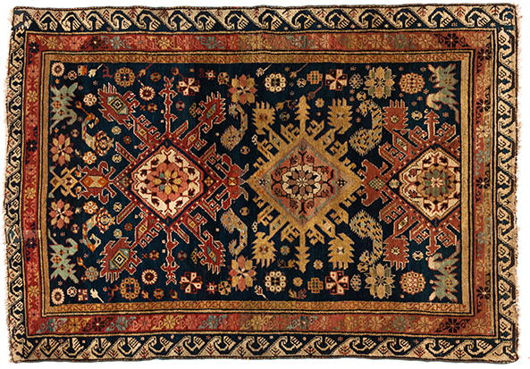 A SEICHOUR RUG, CAUCASIA, CIRCA 1920 the indigo-blue field with three sunburst medallions depicted