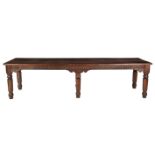 AN OAK TABLE, 19TH CENTURY the rectangular top above a shaped and carved frieze, on faceted tapering
