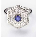 A TANZANITE AND DIAMOND RING centred with a circular mixed-cut tanzanite weighing 0.34cts, within