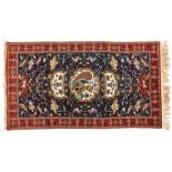 A QUM RUG, PERSIA, MODERN the indigo field with an ivory pictorial medallion and pendant, all with