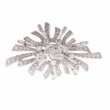 A DIAMOND BROOCH of stylised design, centered with round brilliant- and trillion-cut diamonds