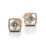 A PAIR OF BLUE TOPAZ AND DIAMOND EAR STUDS each of square form, centered with a princess-cut blue