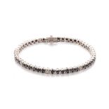 A BLACK AND WHITE DIAMOND BRACELET claw-set with forty-four circular black diamonds weighing
