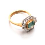 AN EMERALD AND DIAMOND RING centred with a bezel-set emerald step-cut emerald weighing approximately