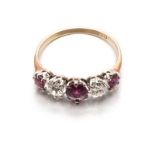 A RUBY AND DIAMOND RING centred with a claw-set oval mixed-cut ruby weighing approximately 0.