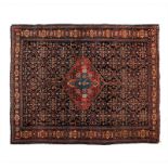 A SENNE RUG, WEST PERSIA, CIRCA 1940 the deep indigo-blue field with a stepped red medallion and "