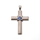 A TANZANITE PENDANT in the form of a cross, with matte finish, centred with a circular tanzanite