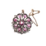 A RUBY AND DIAMOND BROOCH of circular form, centred with an oval mixed-cut ruby weighing