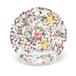 A CHINESE FAMILLE ROSE PLATE, 19TH CENTURY profusely painted with polychrome flowerheads against a