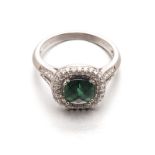 A GREEN TOURMALINE AND DIAMOND RING, BROWNS centred with a faceted cushion-cut green tourmaline