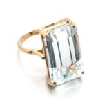 AN AQUAMARINE RING centred with a claw-set emerald-cut aquamarine weighing 18.887cts, impressed 750,