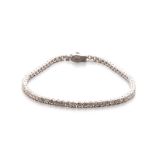 A DIAMOND TENNIS BRACELET designed as a line of sixty eight claw-set round brilliant-cut diamonds