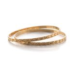 TWO 18CT GOLD BANGLES each of circular form, embellished with star design, impressed 18ct, inner