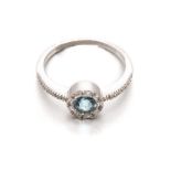 A BLUE TOPAZ AND DIAMOND RING centred with a faceted circular blue topaz, within a conforming