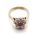 A RUBY AND DIAMOND RING of flower design, centred with a circular ruby weighing approximately 0.