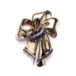 A 9K YELLOW GOLD, SAPPHIRE AND DIAMOND BROOCH resembling a ribbon, comprising 11 round blue