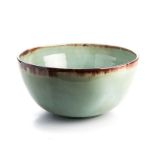 A LINN WARE BOWL, 20TH CENTURY covered in a cloudy apple-green glaze thinning to an iron-oxide