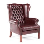 A CLOSENAILED LEATHER UPHOLSTERED WINGBACK ARMCHAIR MANUFACTURED BY GORDON FRASER the padded