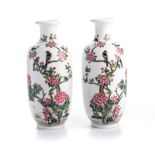 A PAIR OF CHINESE FAMILLE ROSE TRUMPETNECKED ‘MAGPIE AND PRUNUS’ VASES each of tapered cylindrical