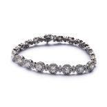 AN 18K WHITE GOLD AND DIAMOND BRACELET 20 approximate 0.10ct diamonds, each surrounded by 12 0.