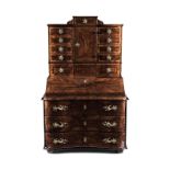 AN AUSTRIAN WALNUT-VENEERED SECRÉTAIRE-ON-CHEST in two parts, the shaped moulded top surmounted by a