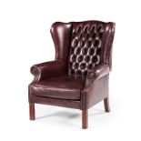 A CLOSENAILED LEATHER UPHOLSTERED WINGBACK ARMCHAIR MANUFACTURED BY GORDON FRASER the padded