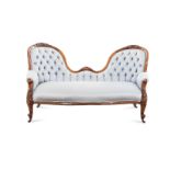 A VICTORIAN WALNUT SETTEE the curved top rail centred by a scrolled and foliate carved cresting,