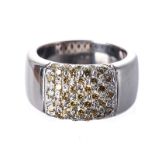 A DIAMOND RING the broad tapered band, pave-set to the centre with fancy yellow round brilliant-