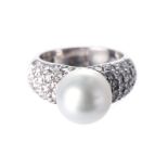 A DIAMOND AND PEARL RING The tapered band pave-set to the centre with round brilliant-cut diamonds